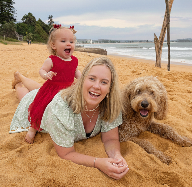 Marieke with baby Joy and dog Buddy lying together on the beach
