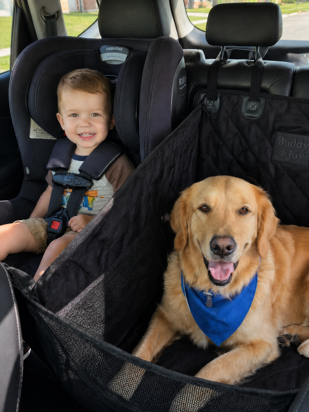 A golden retriever dog and a young child sitting in a car's backseat, both secured by a black quilted car seat cover with mesh side panels. Buddy & Joy left side hammock